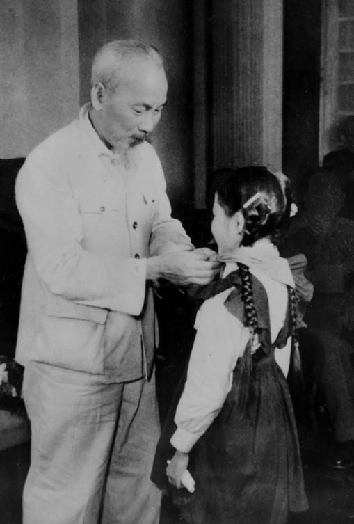 President Ho Chi Minh puts a red scarf on a Hanoi child, who comes to congratulate the 30th founding anniversary of the Communist Party of Vietnam (1960). (Photo: VNA Document)