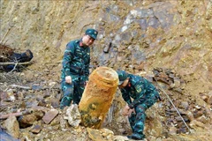 Military personnel work to remove the bomb. (Source: VNA)