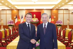 Party General Secretary To Lam (R) receives French President Emmanuel Macron in Hanoi on May 26. (Photo: VNA)