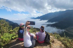 Tourists experience the Divine Rock tour in La Pan Tan commune, Mu Cang Chai district, Yen Bai province. (Photo: VNA)