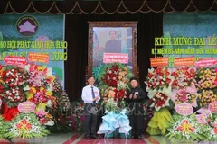 Bui Van Tang (left), Vice President of the Vietnam Fatherland Front Committee of An Giang province, extends congratulations at the grand ceremony marking the 86th founding anniversary of Hoa Hao Buddhism on June 13. (Photo: VNA)