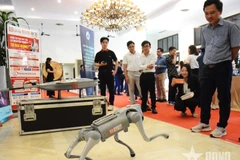 Delegates experience artificial intelligence products displayed at a workshop themed "Artificial Intelligence - New driving force for Da Nang's development". (Photo: qdnd.vn)