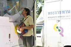 A health worker takes swab samples from a woman for a rapid antigen test in Bangkok, Thailand. (Photo: XINHUA/VNA)