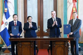 Prime Minister Pham Minh Chinh (second from left) and President of the Dominican Republic Luis Abinader Corona witness the signing of the Memorandum of Understanding on cooperation between the Diplomatic Academy of Vietnam and the Diplomatic and Consular of the Dominican Republic. (Photo: VNA)