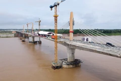 Laos and Thailand put the final touches to their friendship bridge No.5 on June 6. (Photo: VNA)